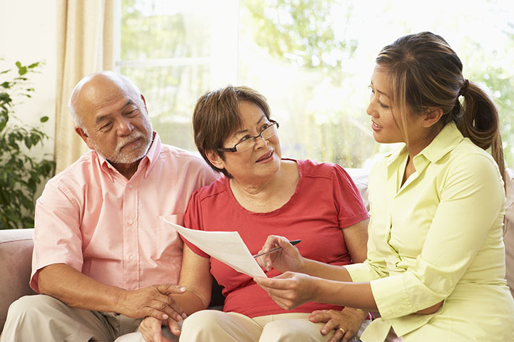 elderly couple meeting with insurance agent at home