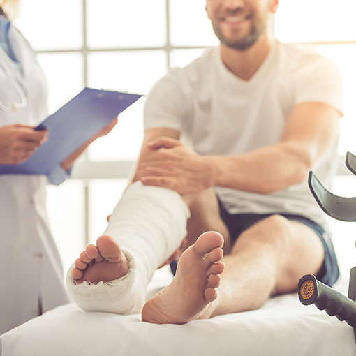 Accident Coverage Insurance Man with leg cast talking to doctor